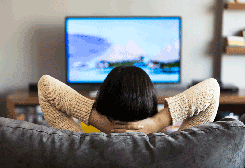 Woman sitting on couch watching TV